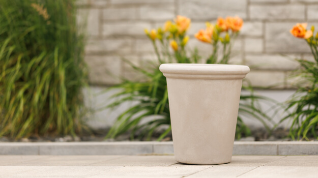 Pot pour patio posé sur pavé uni, belle maison haut de gamme et moderne en pierre.